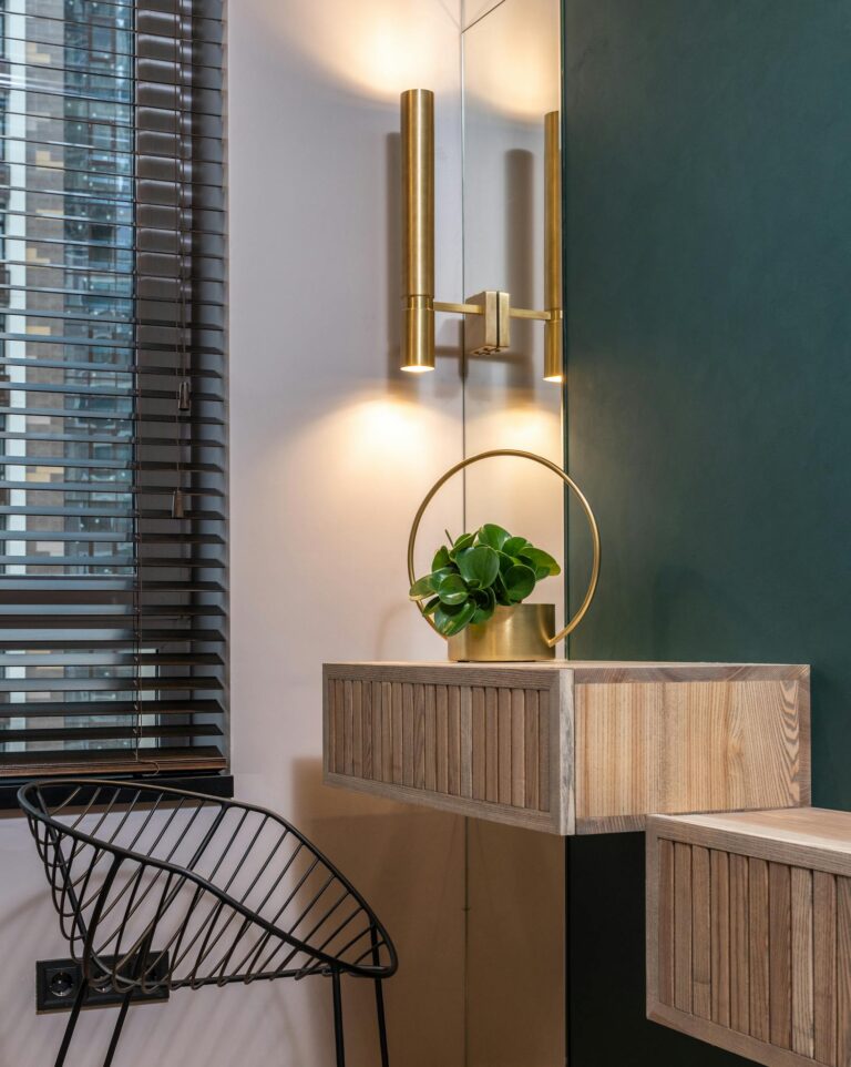 Stylish interior corner with a minimalist vanity, modern lighting, and a decorative plant adding elegance.